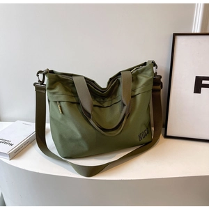 Macro view of army green canvas tote bag with wide strap and side zipper pocket