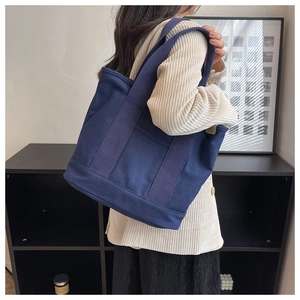Deep blue canvas tote bag detail showing heavy texture and sturdy wide shoulder straps