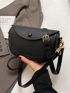 Minimalist black lychee leather saddle bag with gold metal hardware for daily commute