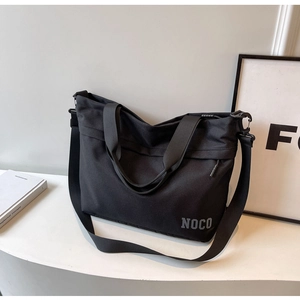 Detail view of large capacity black oxford tote with NOCO branding and detachable strap