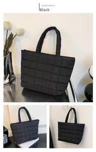 Detail of black quilted tote bag with square stitching and soft padded nylon texture