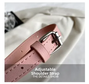 Detailed macro of pink leather adjustable shoulder strap with silver buckle and fine stitching