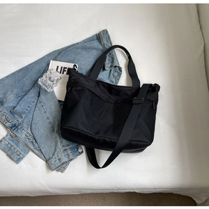 Detail of black large capacity oxford tote bag with adjustable strap in casual lifestyle setting