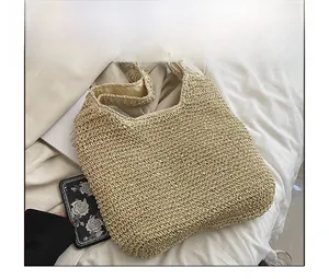 Macro detail of natural straw weave texture and sturdy shoulder strap on a tote bag