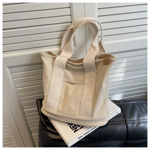 Detail of minimalist canvas tote bag with outer pocket on books with urban decor