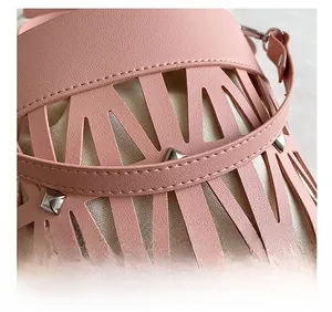 Detail of pink laser-cut handbag with silver studs and canvas drawstring liner