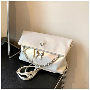 Close-up of white PU leather tote with silver butterfly detail and thick metal chain strap