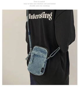 Detail der blauen Denim-Umhängetasche für Handys mit Fransenkanten und Seitenetikett