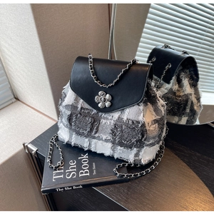 Detailansicht des Tweed-Mini-Rucksacks mit silberner Blumenschließe und Kettenriemen