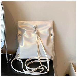 Detail of pearlescent white multi-way tote bag showing iridescent texture and silver hardware