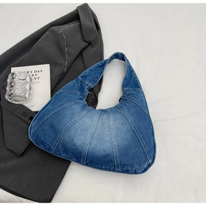 Detail van vintage gewassen blauwe denim hobo tas met patchwork en geplooide textuur