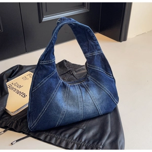 Detail van vintage denim hobo tas met waaiervormige stiksels op een leren jasje
