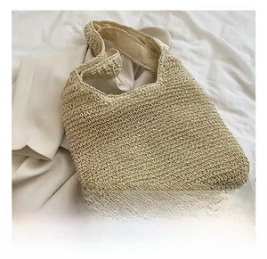 Close-up of woven straw texture and large capacity hobo design on a beige beach tote bag