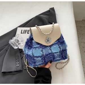 Detail des blauen Denim-Mini-Rucksacks mit Kettenriemen und Blumenverschluss