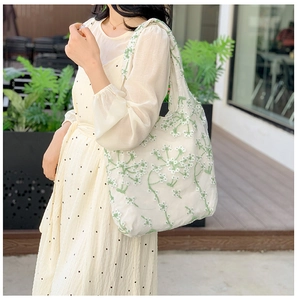 Detail of floral embroidery on white lace mesh tote bag with high-quality stitching