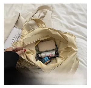 Detailed view of spacious straw tote interior with zippered lining and daily essentials