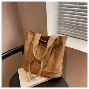 Detailed view of camel canvas tote bag showing thick fabric texture and shoulder strap