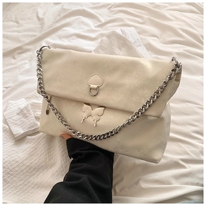 Detail of cream PU leather crossbody bag with butterfly patch and chunky silver chain