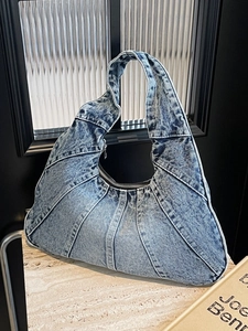 Retro gewassen denim patchwork hobo tas met zilveren rits op marmeren blad