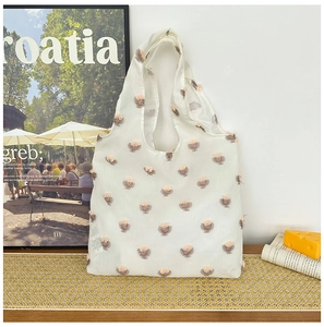 Detail of white semi-transparent tote bag with 3D floral accents and elegant texture