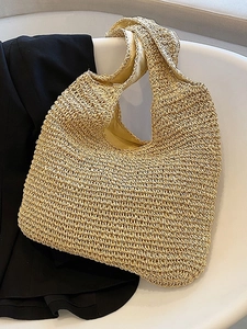Handwoven beige straw tote bag with crochet texture on a minimalist white chair