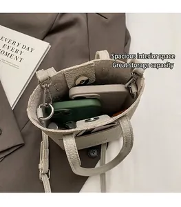 Interior view of mini bucket bag showing capacity for smartphones and lipstick