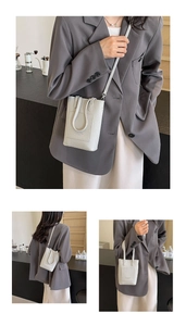 Détail d'un sac seau beige avec texture grainée et double poignée élégante