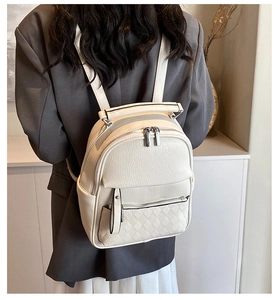 Detailed back view of a woman wearing the quilted beige leather backpack for school