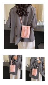 Détail du mini sac bandoulière rose grainé avec poche avant et options de double sangle