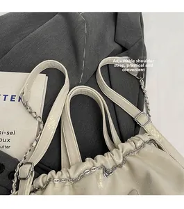Detalle de la correa ajustable de cuero y la cadena plateada de la mochila blanca
