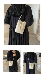 Gros plan du petit sac bandoulière blanc crème en cuir grainé porté par un mannequin