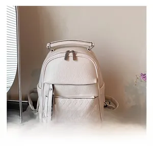Close-up of a white minimalist backpack with quilted diamond patterns and silver zippers