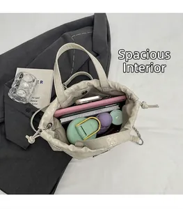 Almacenamiento interno del bolso tipo cubo beige con botella de agua y laptop