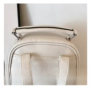 Detail of the thickened handle and silver metal zipper on an off-white leather backpack