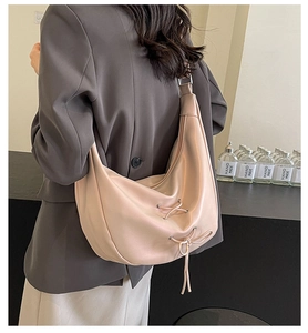 Detail of soft cream-colored hobo bag with unique decorative drawstring cross laces