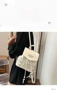 Detail of cream-white leather backpack featuring drawstring cords and side pleats