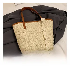 Detailed close-up of woven straw tote bag with lace trim and brown leather handle