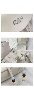 Detailed view of cream pleated backpack with drawstring closure and silver metal hardware