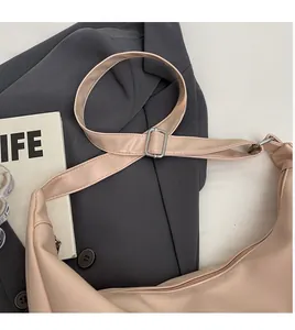 Detail of adjustable long shoulder strap with silver metal buckle on pink tote bag