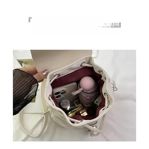 Interior view showing the large capacity and wine red lining of this pleated backpack