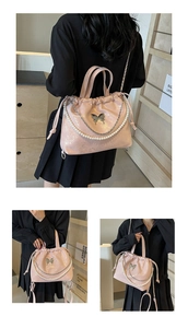 Detalle del bolso plisado rosa brillante con cadena de perlas y adorno de mariposa