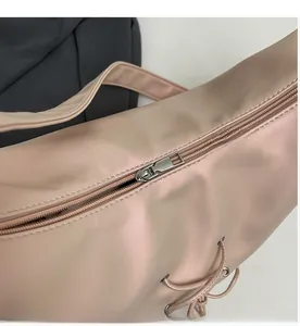 Detail of pink tote bag showing smooth silver metal zipper and drawstring on pearly fabric