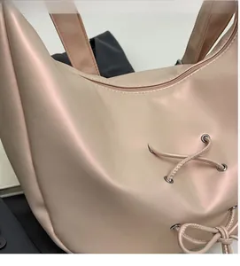 Close-up of soft pink tote bag featuring pearlescent fabric and drawstring detail
