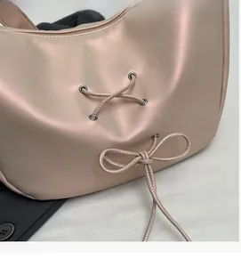 Detail of pink PU leather tote with criss-cross lacing and bow-knot decoration