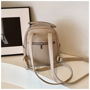 Rear view of beige leather backpack showing hidden zipper pocket and side compartments