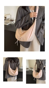 Detail of light pink crescent bag showing drawstring bow and smooth faux leather texture