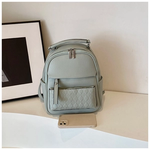 Close-up of light green quilted faux leather backpack with side pocket and phone size reference