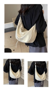 Detail view of cream-white leather dumpling bag featuring decorative ribbon bow ties