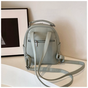 Detailed back view of a mint green mini backpack with adjustable straps and rear zipper pocket