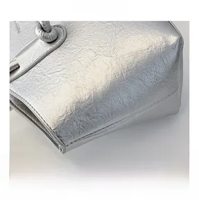 Gros plan sur le tissu plissé argenté métallisé et le nœud d'un sac à bandoulière chic